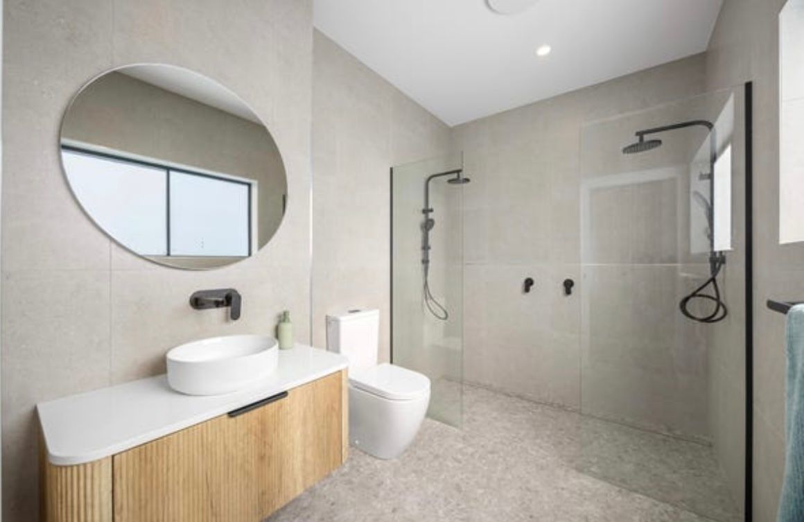A Modern Bathroom With a Wood Vanity — Coastbuilt Building Services in Thrumster, NSW