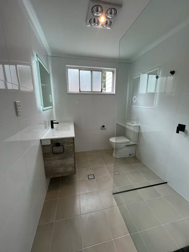 Modern Bathroom With White Tiled Walls — Coastbuilt Building Services in Thrumster, NSW