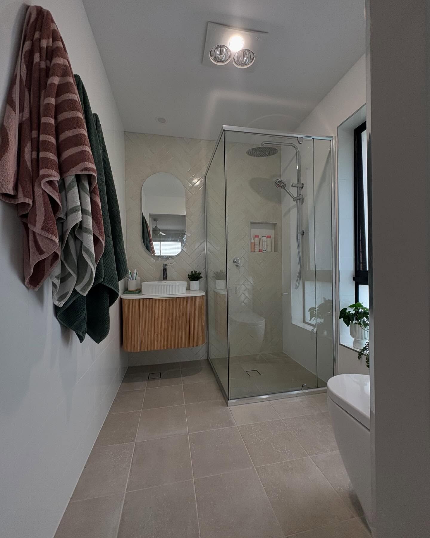 A Modern, Neutral-toned Bathroom Featuring a Glass Walk-in Shower — Coastbuilt Building Services in Thrumster, NSW