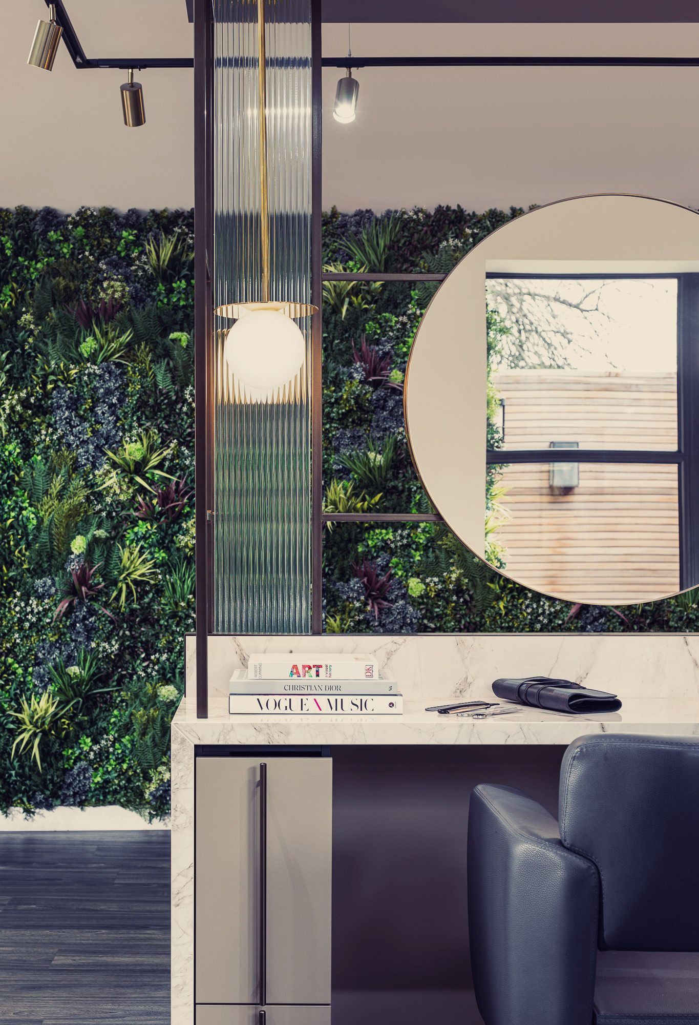Leo Bancroft Modern office with a desk, chair, hanging light, green wall, and circular mirror opening to a bright room.