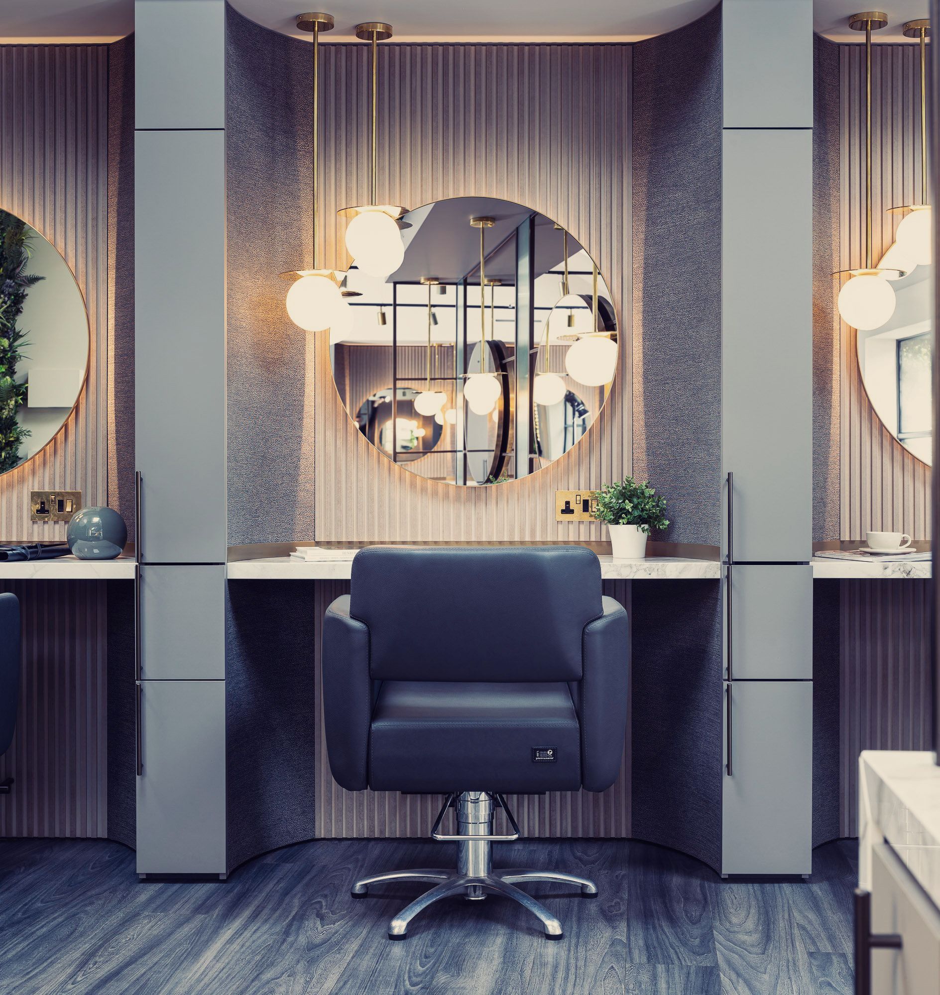 Leo Bancroft Modern salon station with a black chair, round mirror, and soft pendant lights in a blue-gray interior.