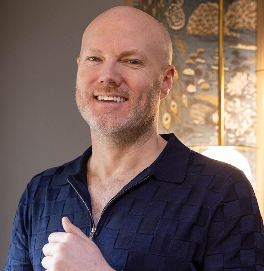 A bald man with a beard is smiling in a circle