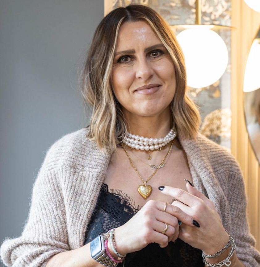 A woman in a polka dot shirt is smiling in a circle