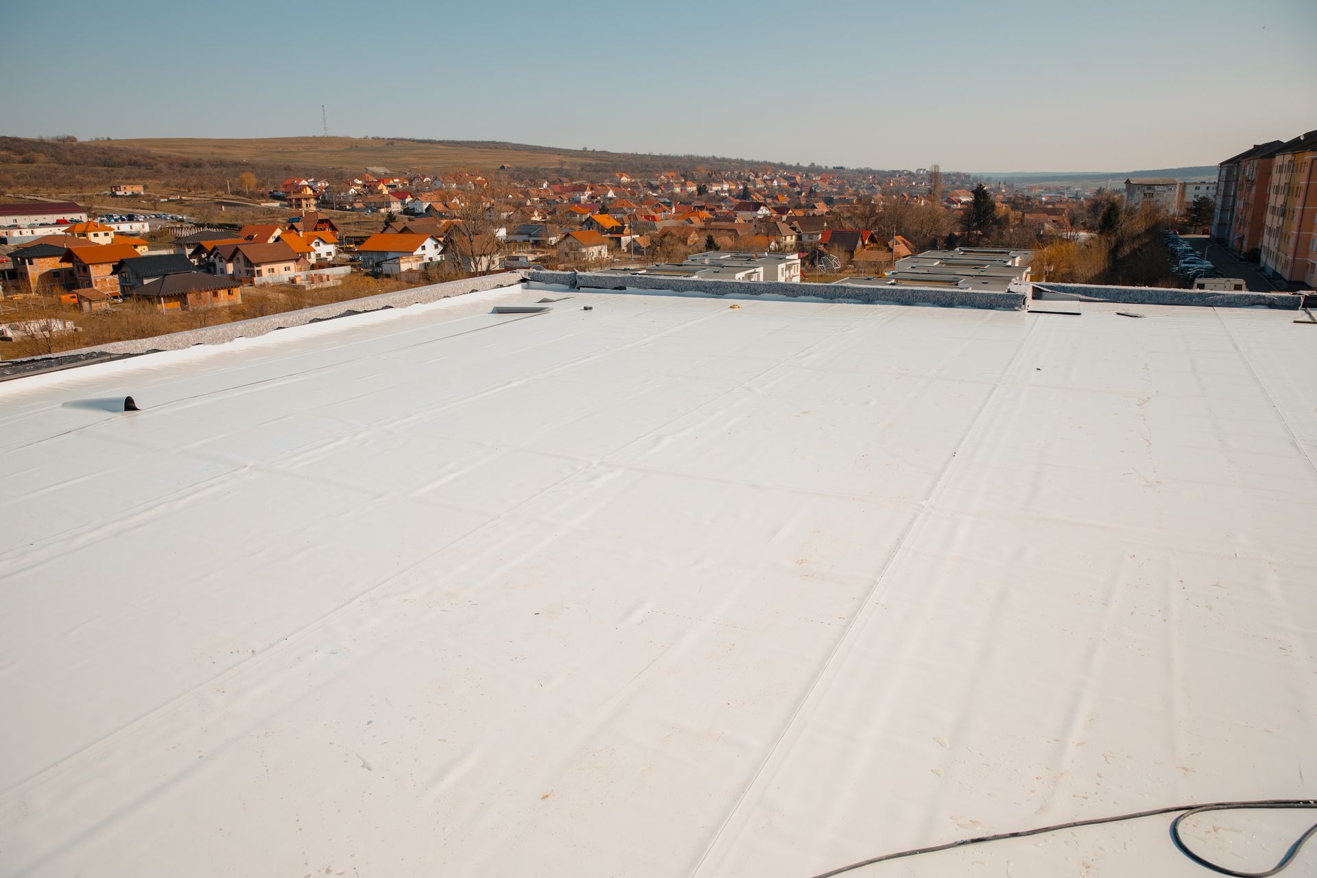 A large white roof with a city in the background