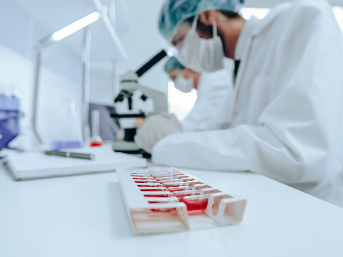 A scientist is looking through a microscope in a laboratory.