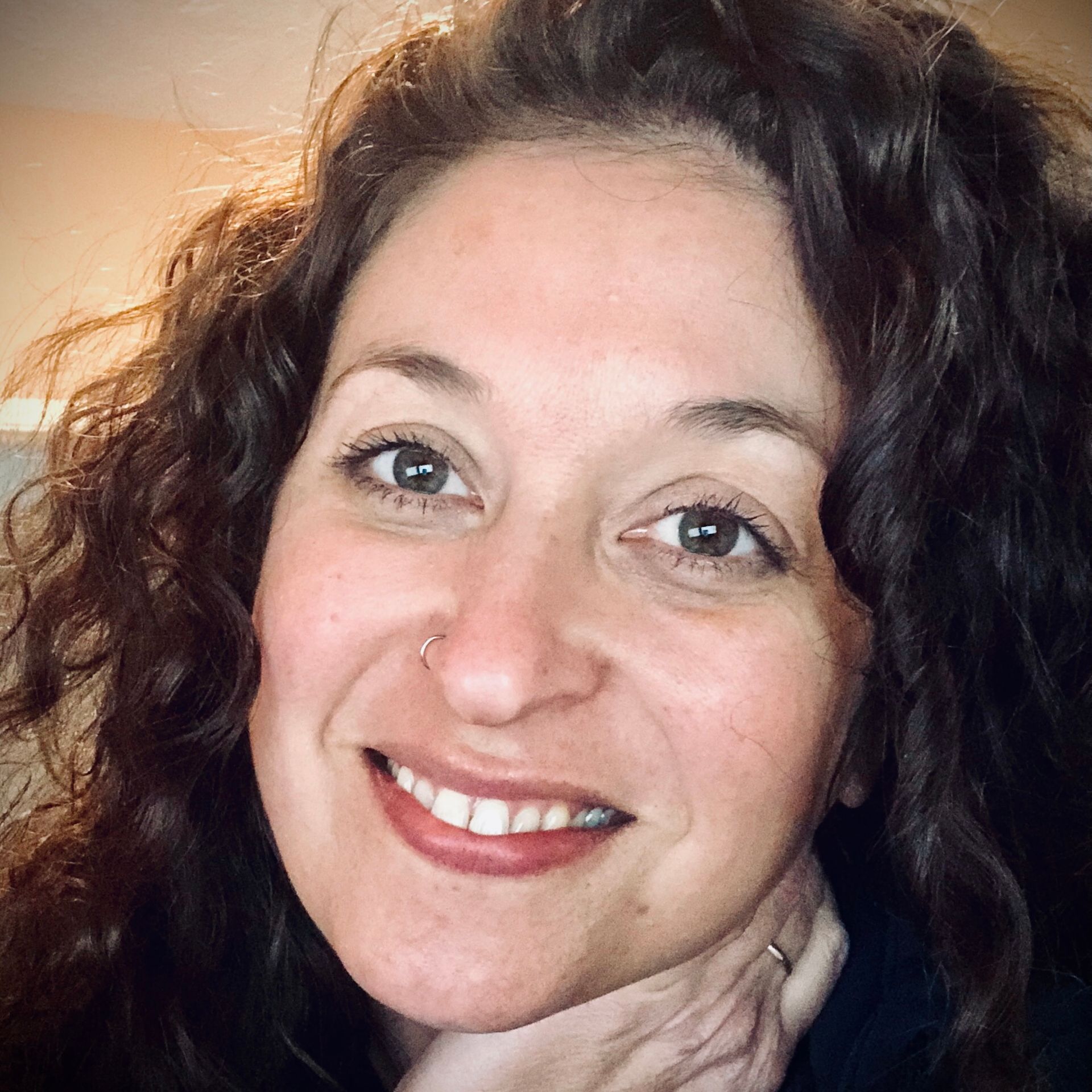 A woman in a white shirt is smiling for the camera.