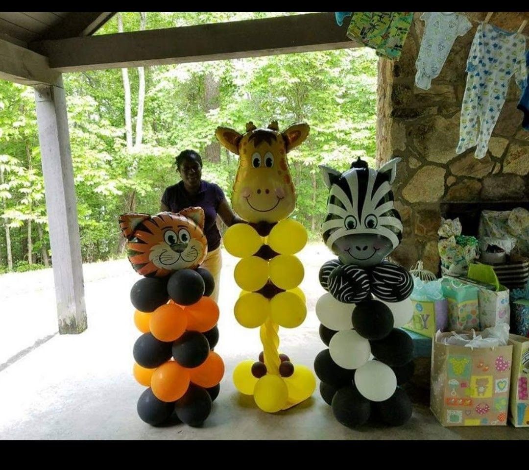 Animal balloon sculptures: tiger, giraffe, zebra, at an outdoor party with gift bags.