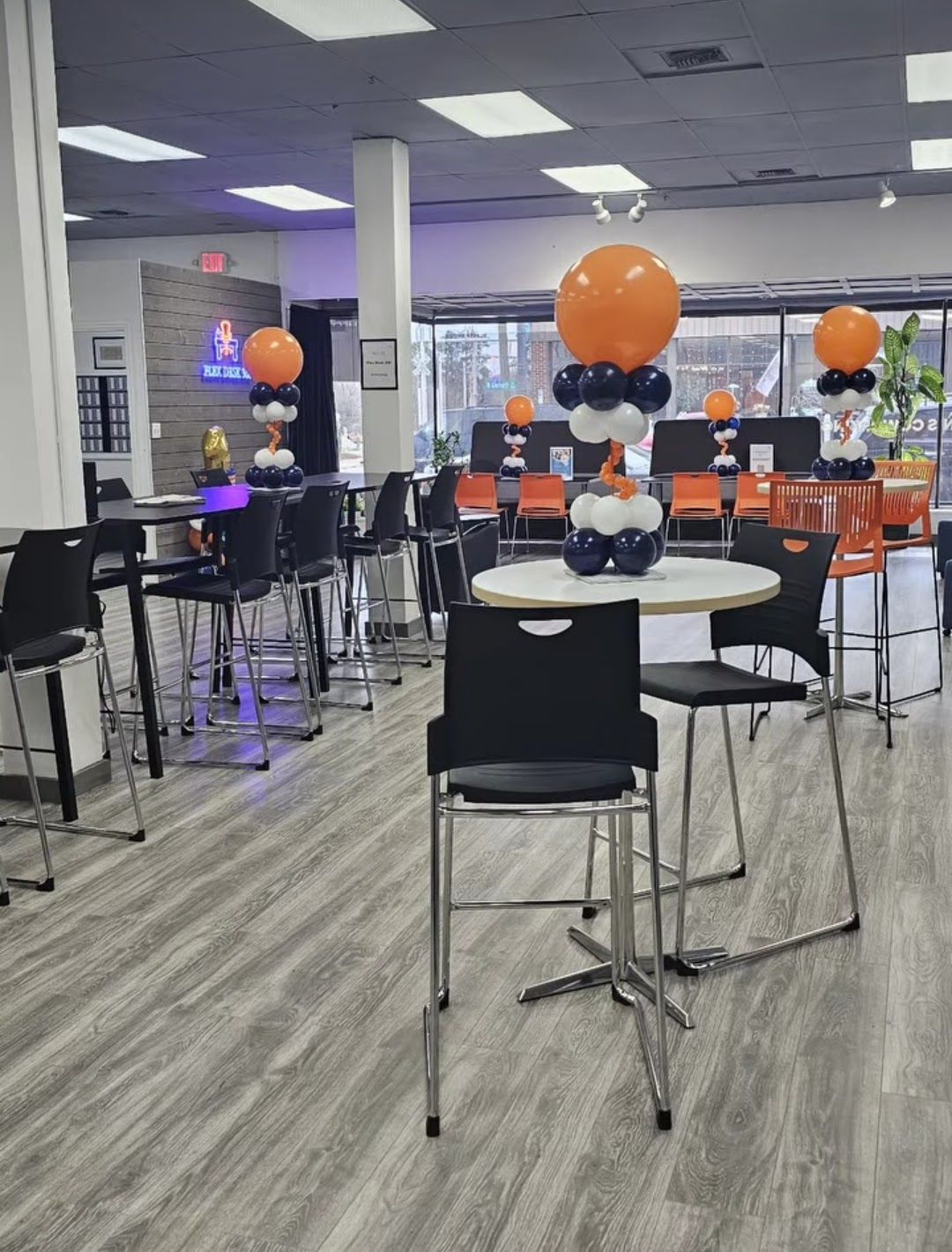 Office Christmas party. Group of people wearing Santa hats, celebrating, holding balloons, and gifts.