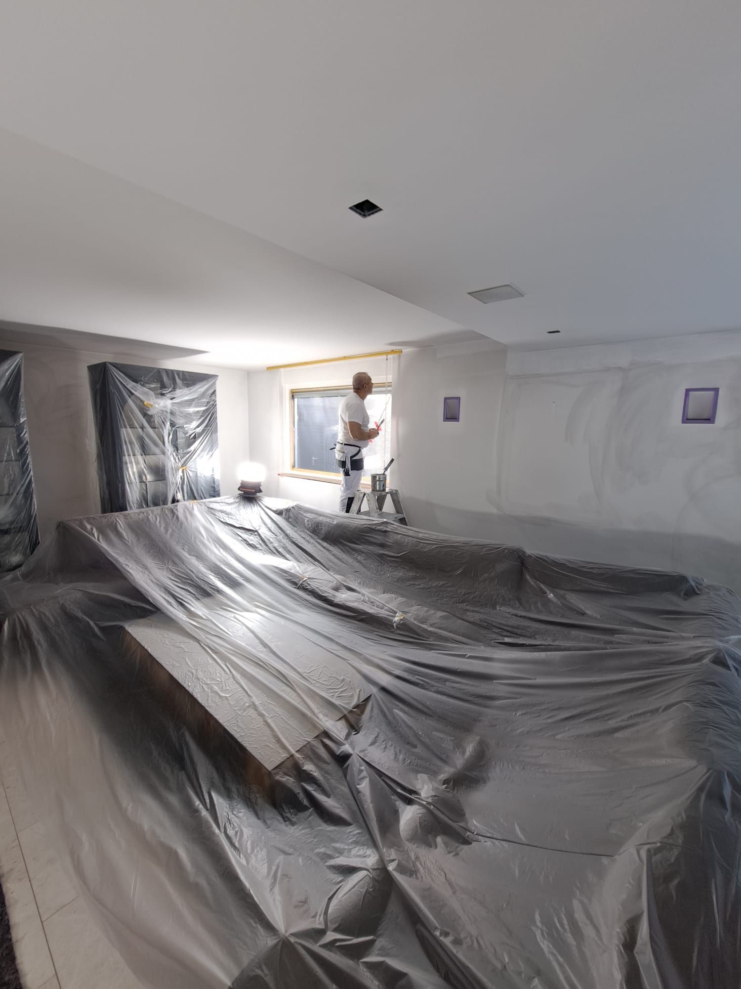 Een man staat in een kamer bedekt met plastic.