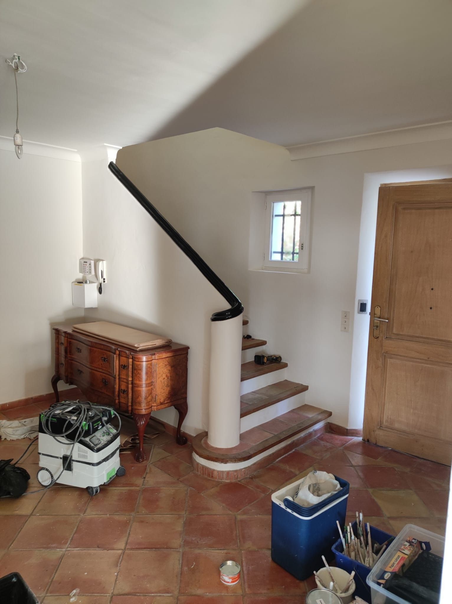 Een kamer met een trap en een dressoir erin