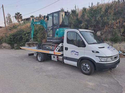 Tecnico che collega un cavo di traino a un veicolo fermo a bordo strada