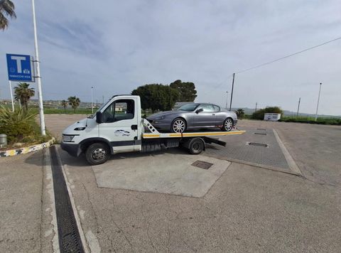 Tecnico che collega un cavo di traino a un veicolo fermo a bordo strada