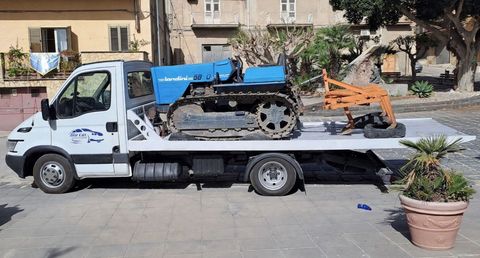 Tecnico che collega un cavo di traino a un veicolo fermo a bordo strada
