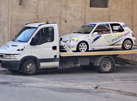 Veicolo di assistenza stradale accanto a un'auto in panne su una strada di campagna siciliana