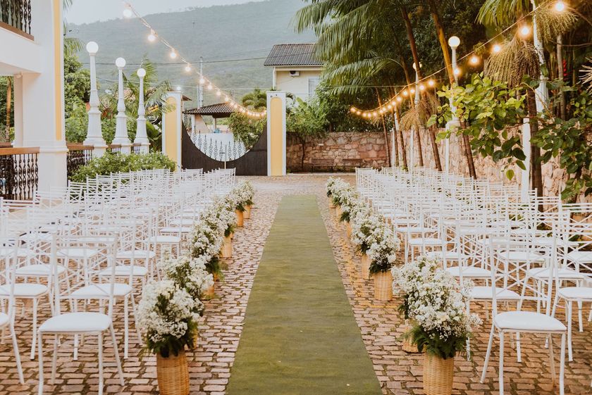 Uma fileira de cadeiras alinhadas para uma cerimônia de casamento.