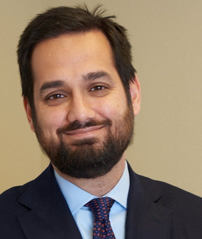 A man with a beard is wearing a suit and tie
