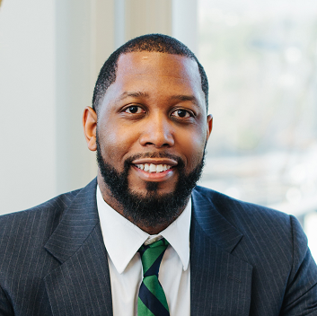 A man in a suit and tie is smiling for the camera