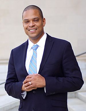 A man in a suit and tie is standing on a set of stairs.