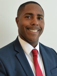 A man in a suit and tie is smiling for the camera.