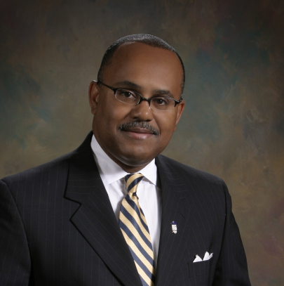 A man in a suit and tie is smiling for the camera