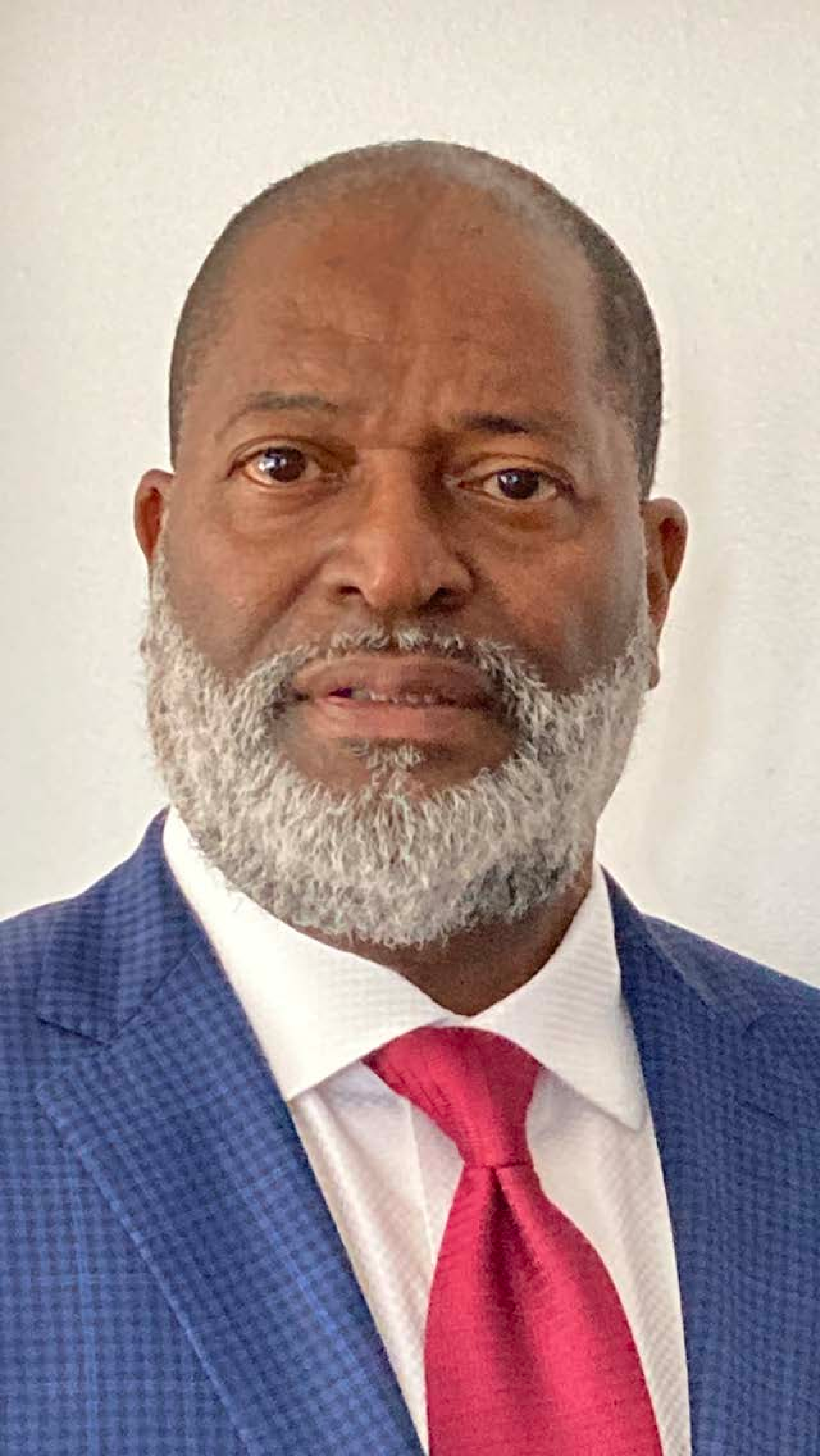 A man with a beard is wearing a suit and tie.