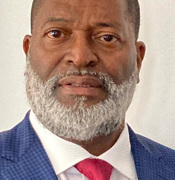 A man with a beard is wearing a suit and tie.