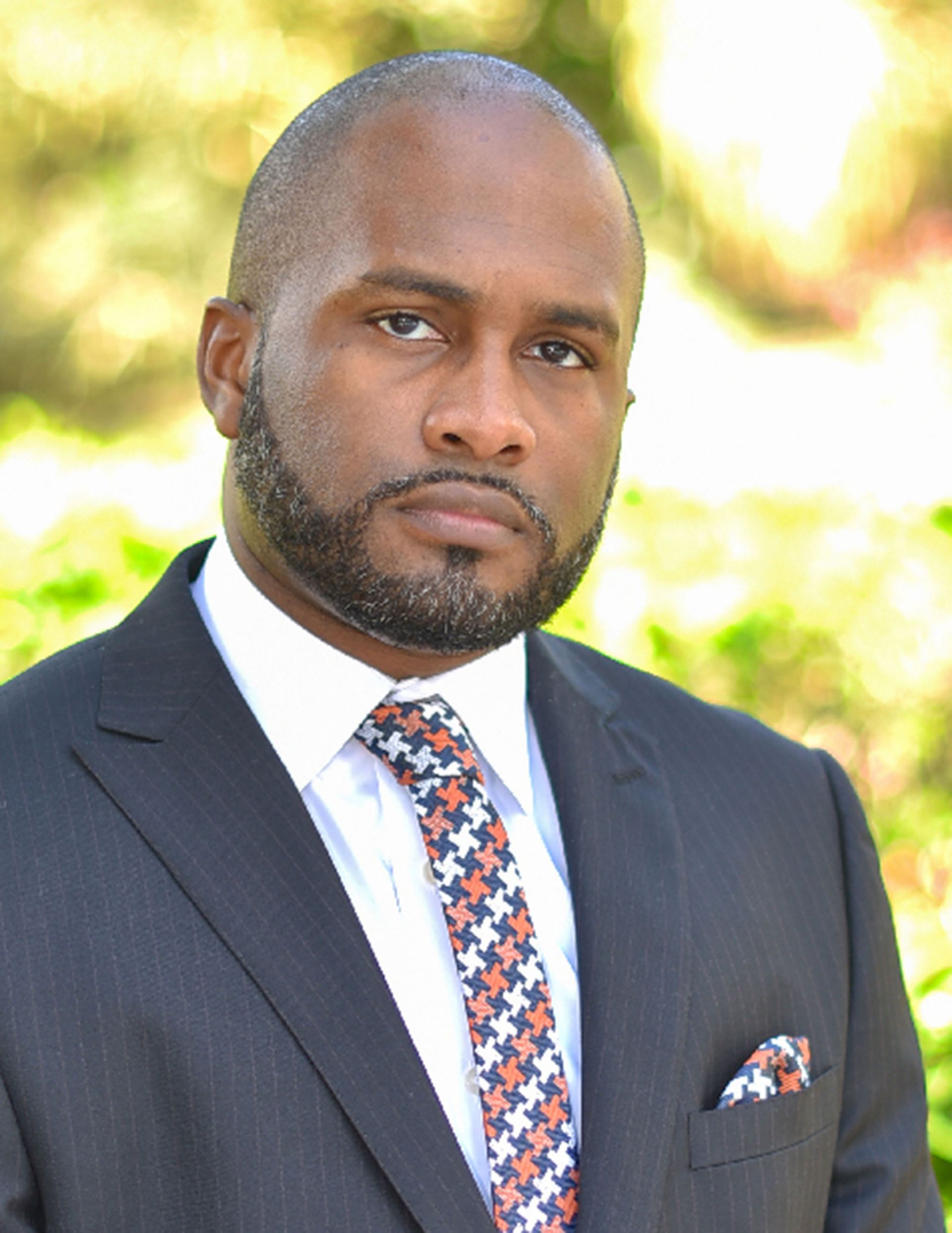 A man in a suit and tie is looking at the camera.