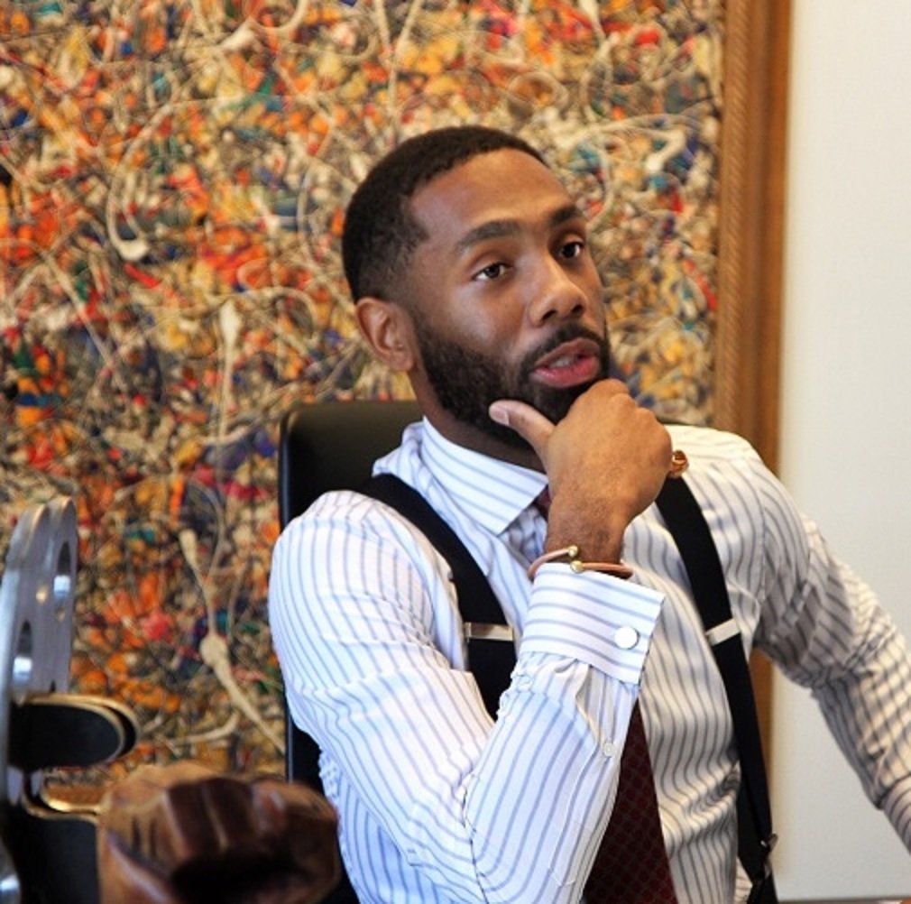 A man with a beard is wearing suspenders and a striped shirt