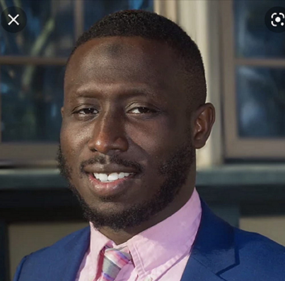 A man in a suit and tie is smiling for the camera.