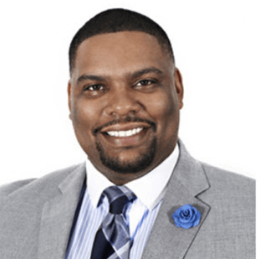 A man in a suit and tie is smiling for the camera