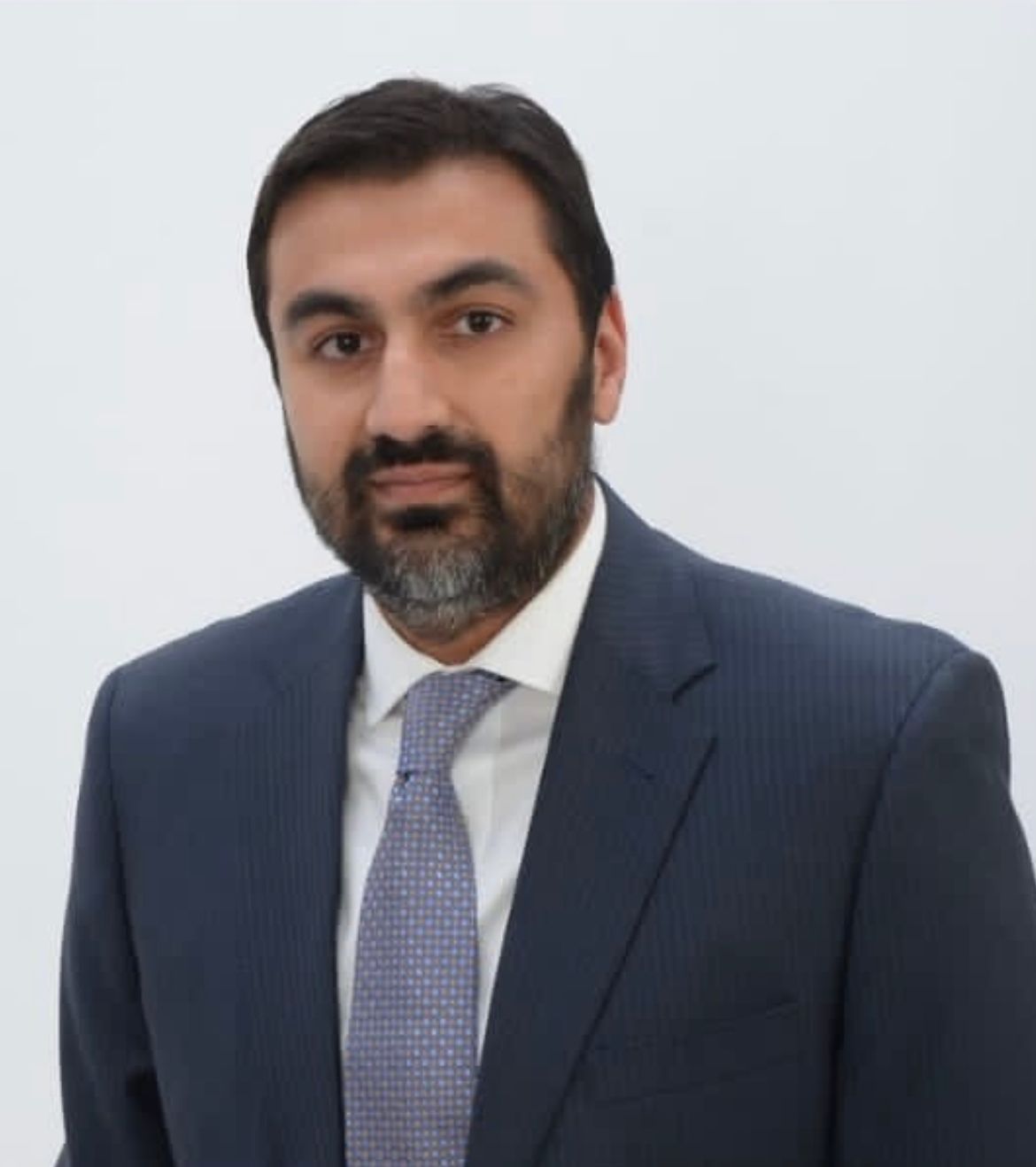 A man with a beard is wearing a suit and tie