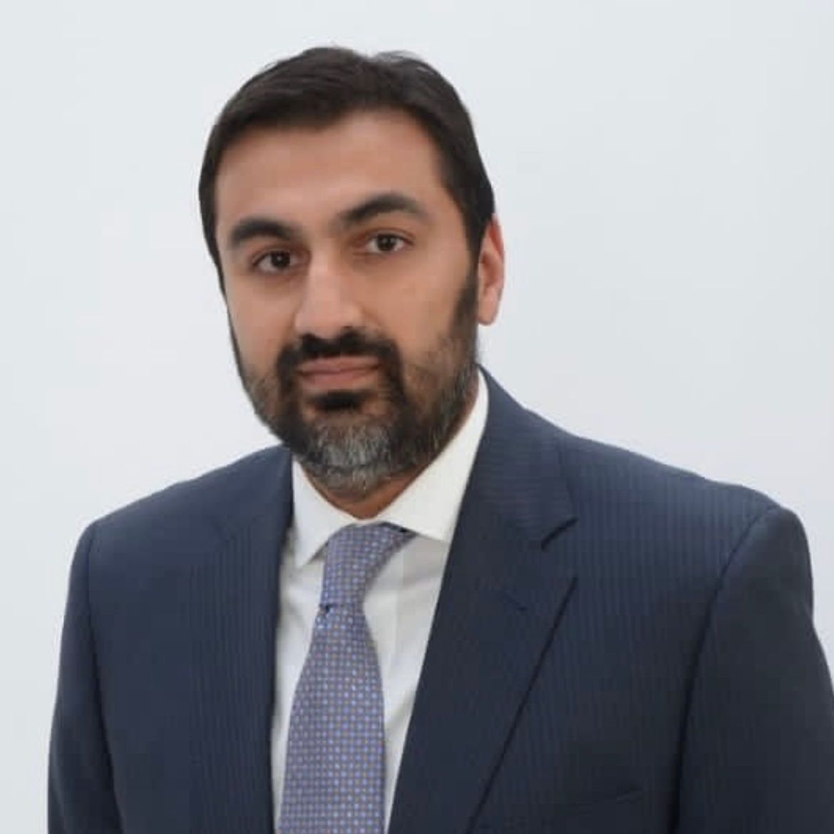 A man with a beard is wearing a suit and tie