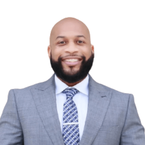 A bald man with a beard wearing a suit and tie