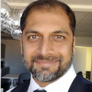 A man with a beard is wearing a suit and tie