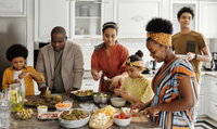 A family is preparing food together in a kitchen.