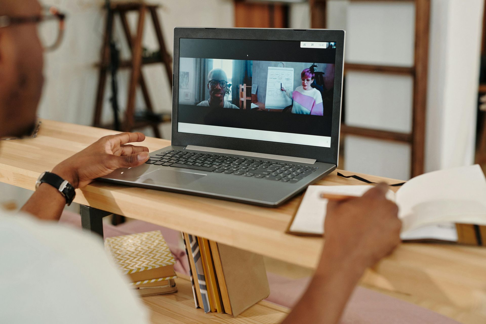 A man is sitting at a desk using a laptop computer.