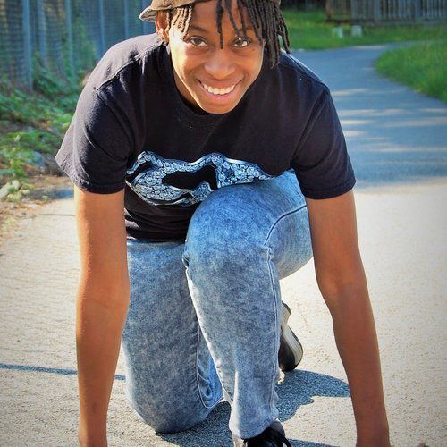A young man wearing a black t-shirt with the letter s on it