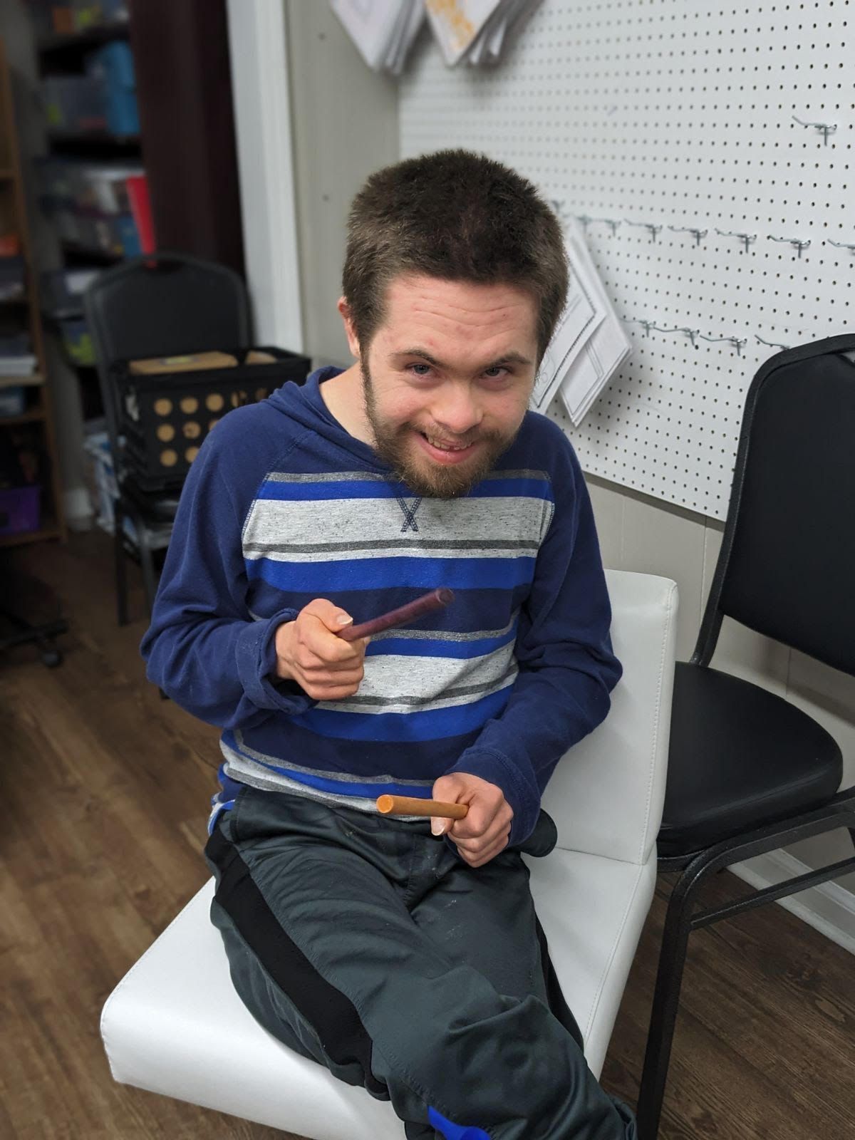 An image of a man holding makeshift drumsticks.