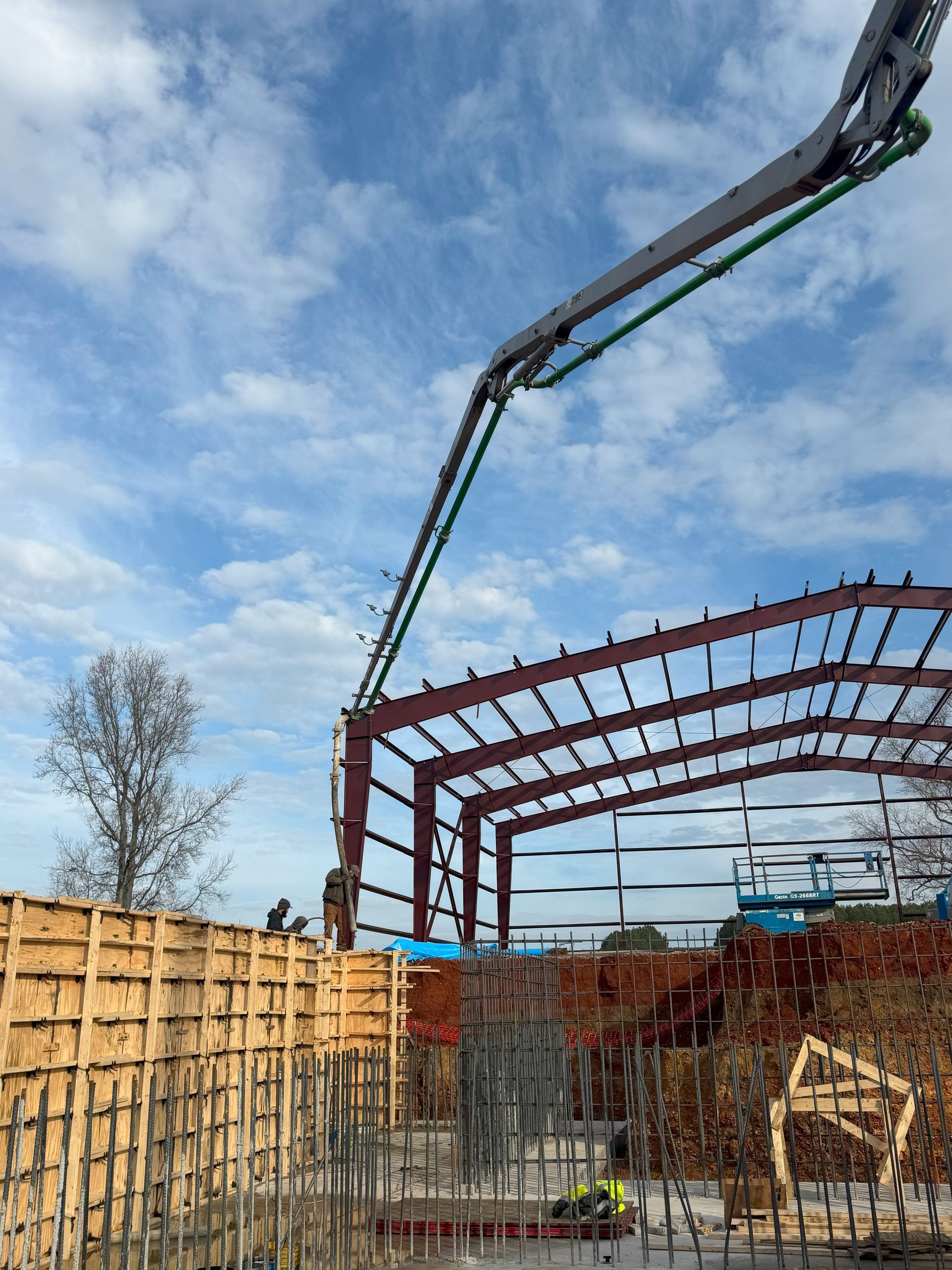 A crane is pouring concrete into a building under construction.