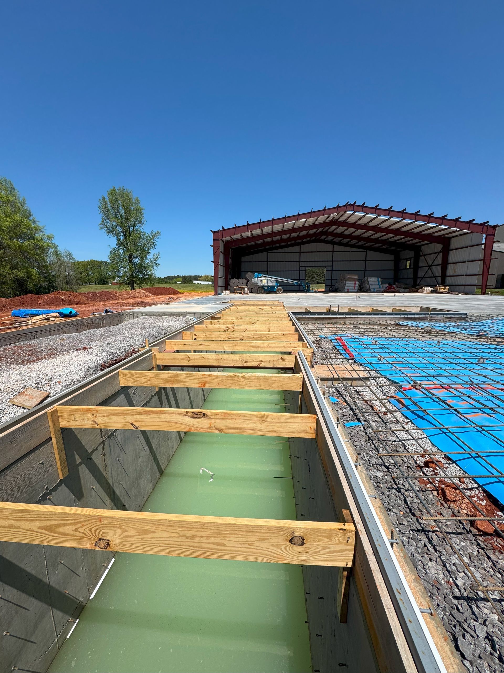 A building under construction with a wooden walkway leading to it.