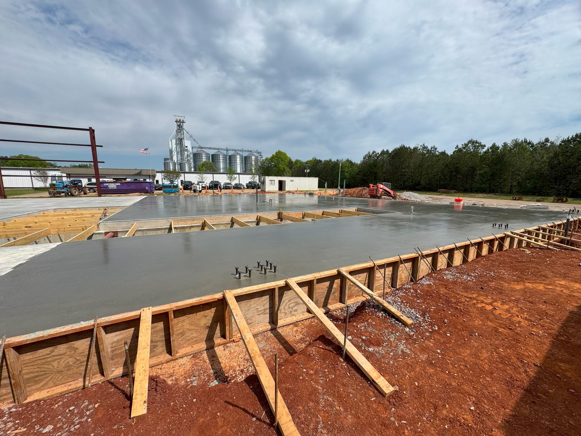 A large concrete slab is being poured on a construction site.