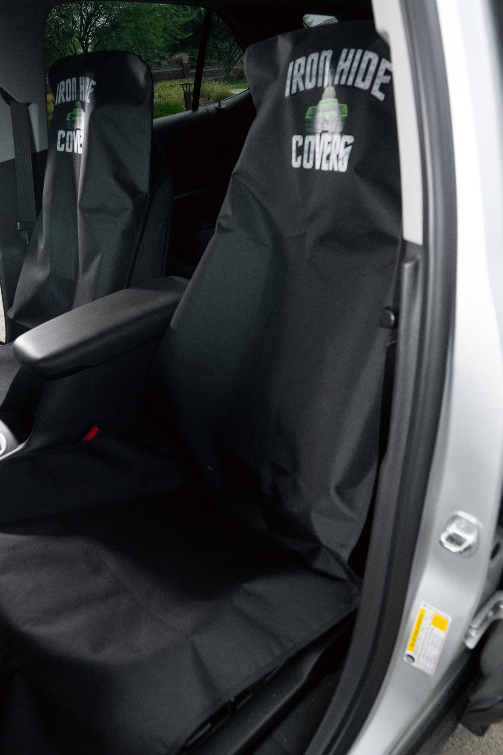 Black seat covers inside a vehicle, with custom logos on the covers