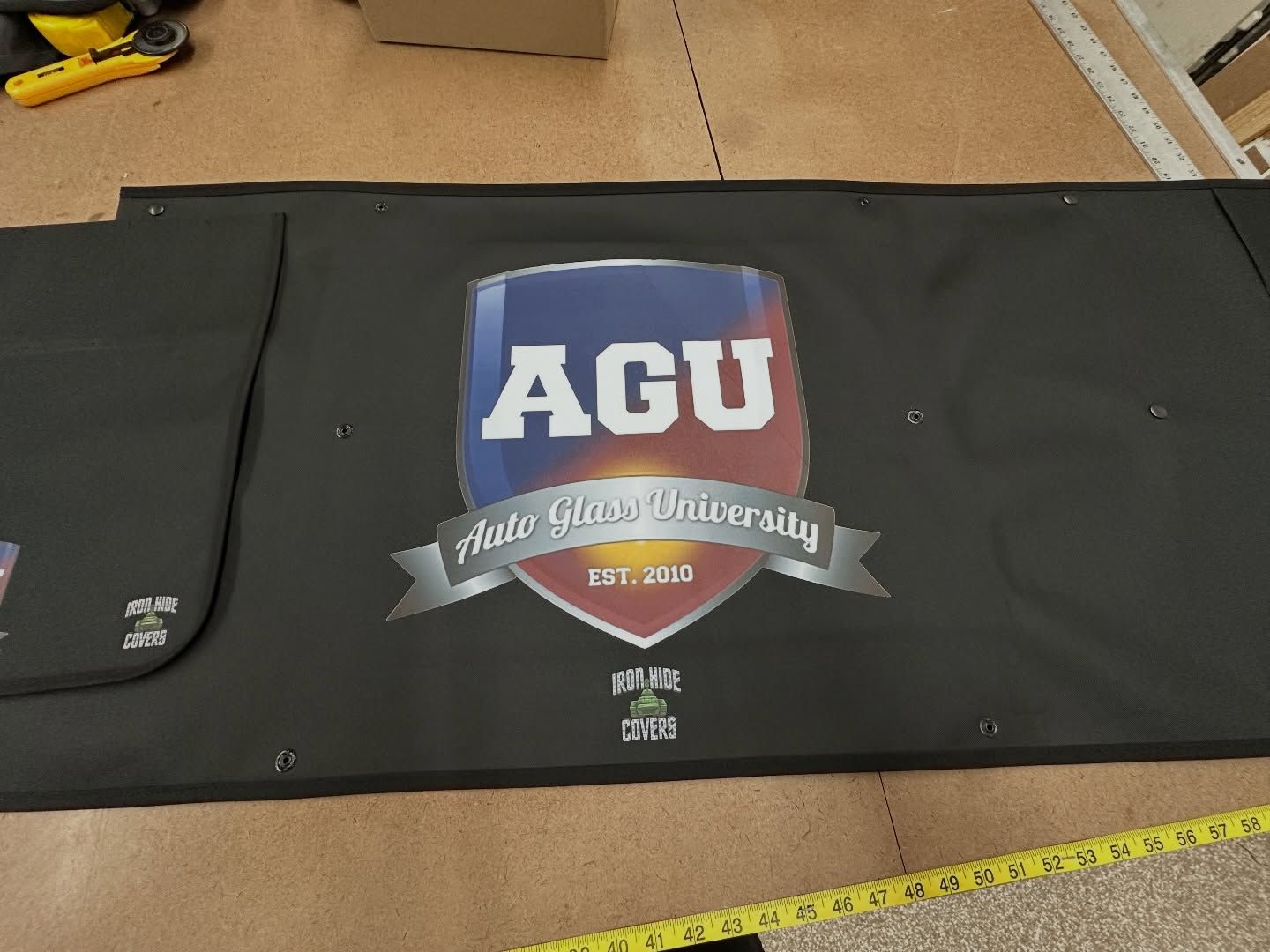 Black AGU custom cover, laid flat on a table.
