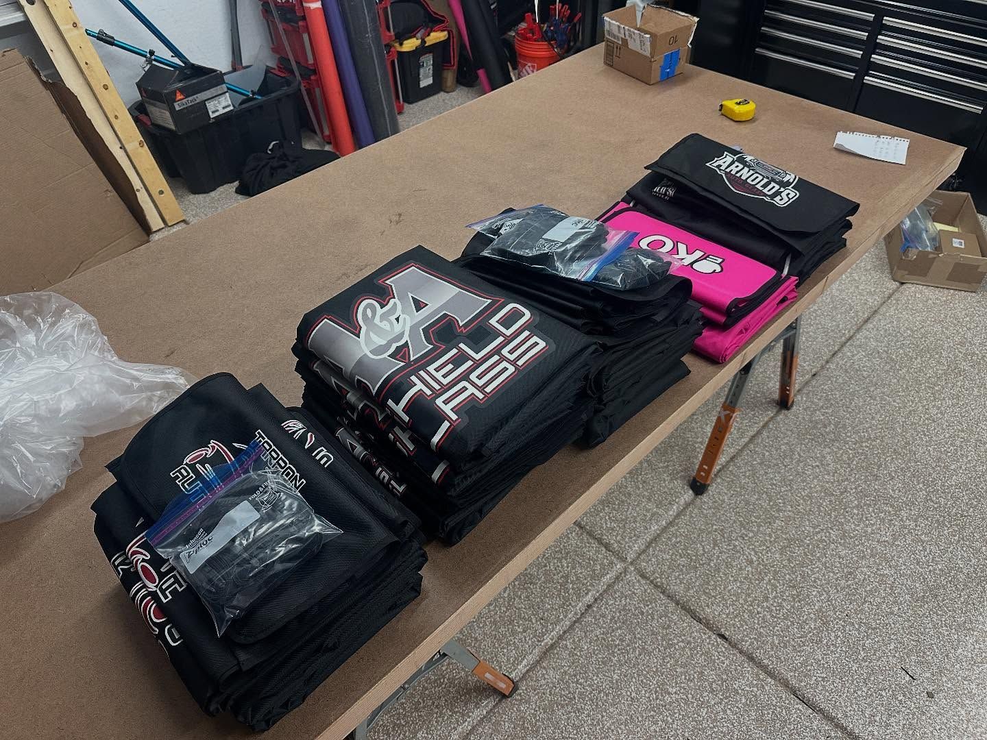 Folded custom car covers arranged on a table in a workshop.