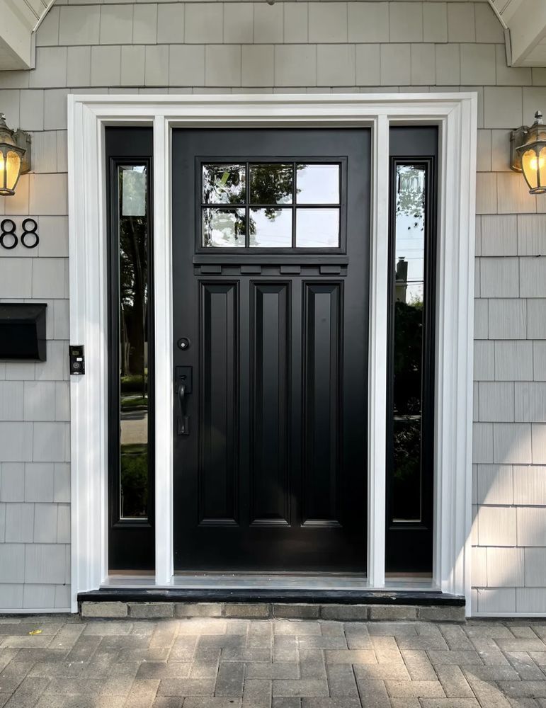 Black front door with white trim and side windows at a house entrance