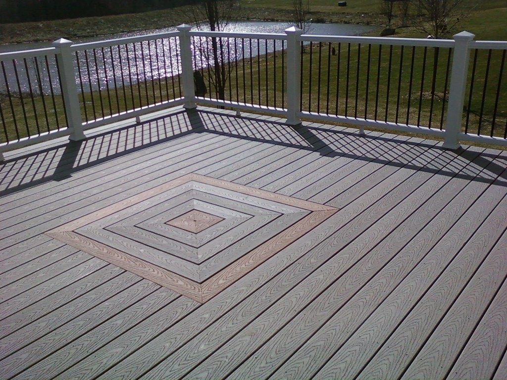 A gray deck with a white railing and a diamond pattern