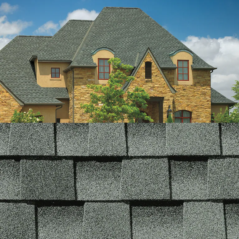 Suburban house behind a gray stone wall under a blue sky
