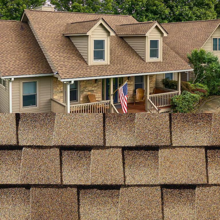 Roof shingles in front of a beige house with an American flag on the porch