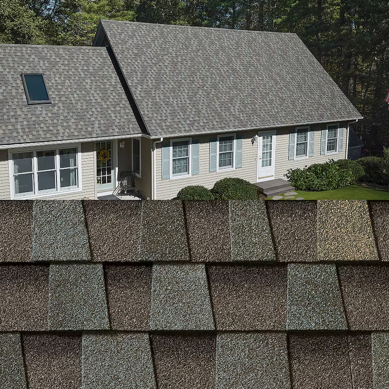 Suburban house with gray shingle roof, seen behind a close-up row of roof shingles
