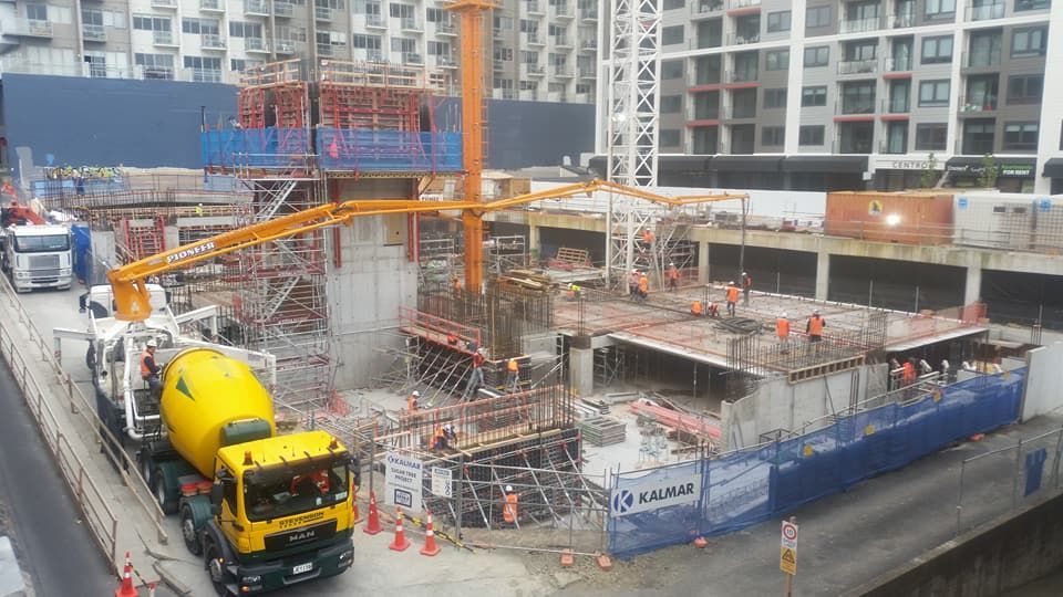A construction site with a concrete mixer truck and a crane.
